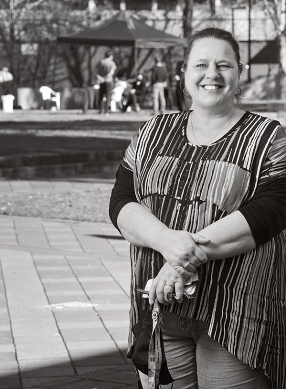 Black and white portrait of Carlijn, standing outside her workplace in Mt Druitt for Fine Photography's COVID vaccination campaign 'Our Call to Arms'.